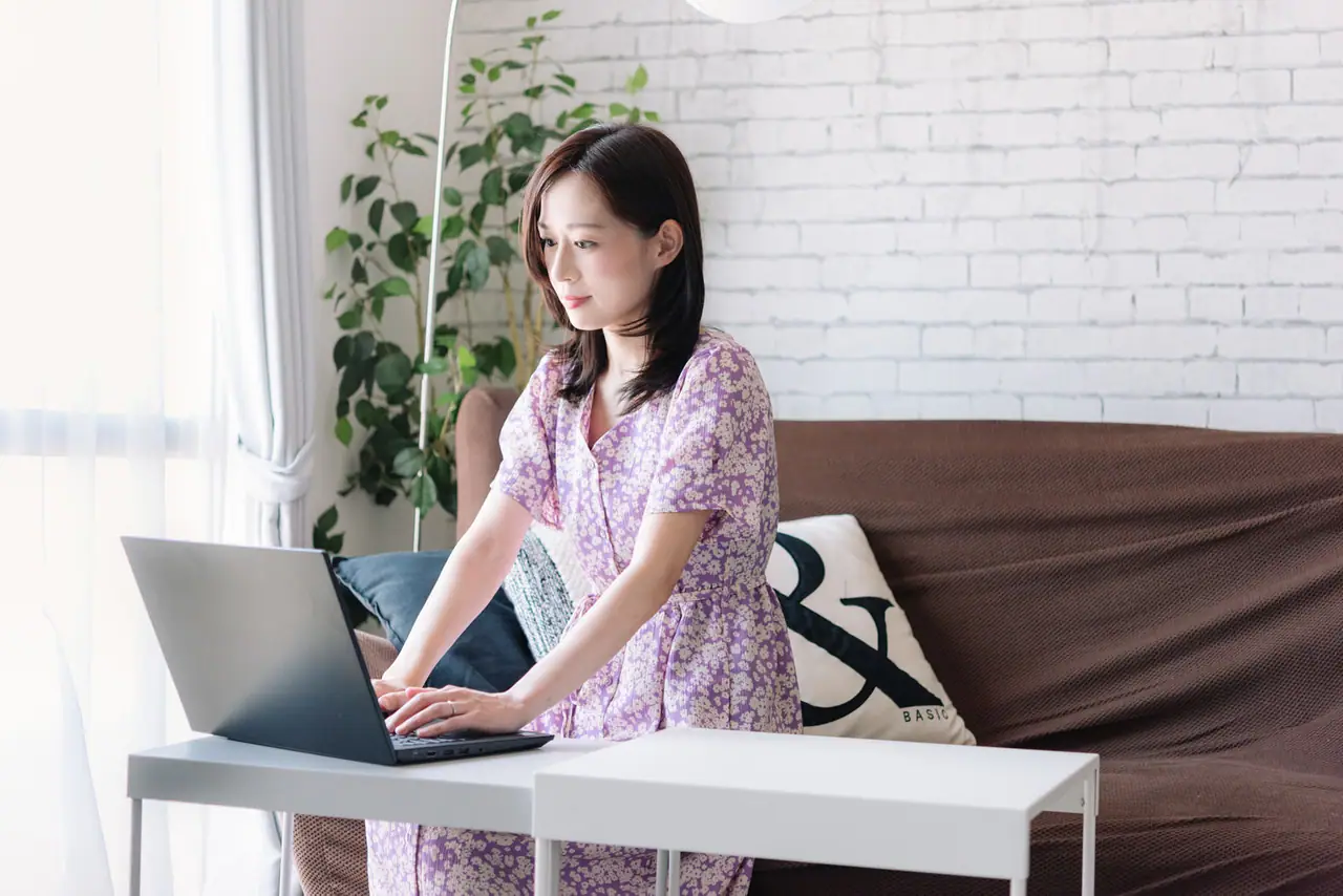 窓辺でテレワークをする女性